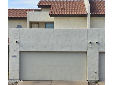 Attached garage with off-white door and security cameras at 7764 N 19Th Dr, Phoenix, AZ 85021