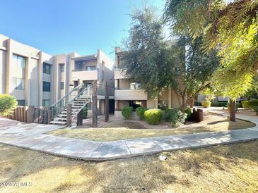 Two-story condo building with landscaping and walkway at 7777 E Main St # 215, Scottsdale, AZ 85251