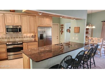 Modern kitchen features granite countertops, stainless steel appliances, and light wood cabinets at 10646 W Boswell Blvd, Sun City, AZ 85373