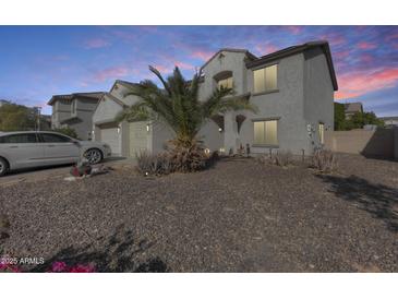 Two-story house with desert landscaping and a car in the driveway at 14206 W Mandalay Ln, Surprise, AZ 85379