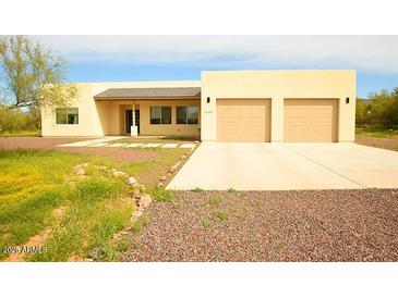 Single-story home with two-car garage and desert landscaping at 1628 E Magellan Dr, New River, AZ 85087