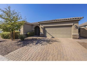 Single-story home with a two-car garage and well-manicured landscaping at 1866 N 214Th Ln, Buckeye, AZ 85396