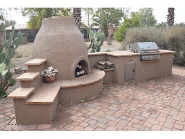 Outdoor kitchen with built-in grill, pizza oven, and stone countertops at 2425 E Durango Dr, Casa Grande, AZ 85194