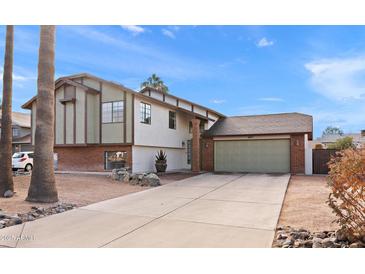 Brick home with a two-car garage and a well-maintained front yard at 4947 E Adobe St, Mesa, AZ 85205