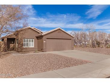 One-story house with two-car garage, desert landscaping, and light brown exterior at 9016 W Harmony Ln, Peoria, AZ 85382