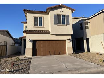 Two-story house with brown garage door and Spanish-style detailing at 9346 E Sequence Ave, Mesa, AZ 85212