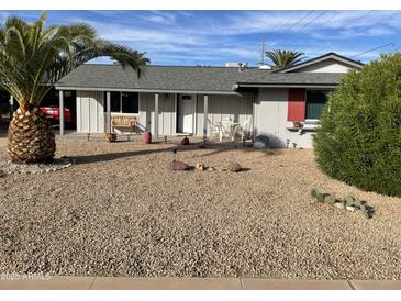 Ranch style home with carport, desert landscaping, and spacious front yard at 9902 W Coggins Dr, Sun City, AZ 85351