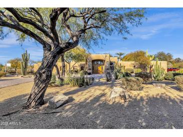 Stunning Southwestern-style home featuring mature trees and desert landscaping, creating an inviting outdoor space at 9980 E Charter Oak Rd, Scottsdale, AZ 85260