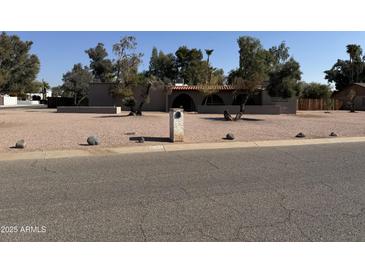 Single story home with desert landscaping and a large front yard at 12435 N 61St Pl, Scottsdale, AZ 85254