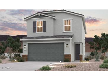 Two-story house with gray siding, gray garage door, and brick accents at 17321 W Jessie Ln, Surprise, AZ 85387