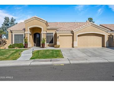 Tan two-story house with three-car garage and lush landscaping at 1890 W Wisteria Dr, Chandler, AZ 85248