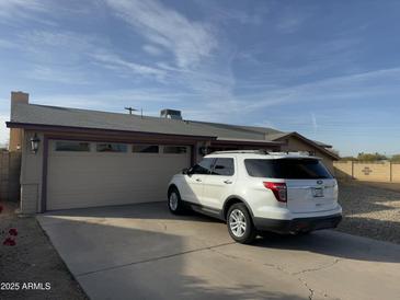 Tan house with a two-car garage and a driveway, set against a clear sky at 4830 S 22Nd Pl, Phoenix, AZ 85040