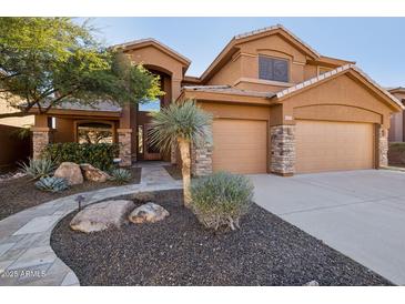 Two-story house with stone accents and a landscaped front yard at 6025 E Palomino Ln, Scottsdale, AZ 85266