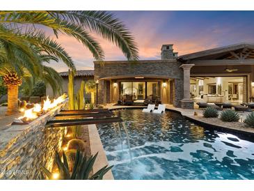 Luxury backyard oasis with a sparkling pool, fire feature, and ample seating at 8124 E Paraiso Dr, Scottsdale, AZ 85255