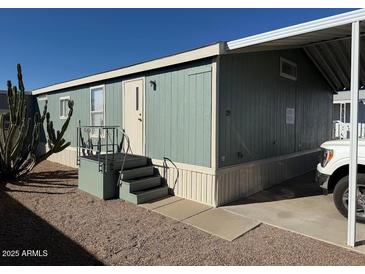 Mobile home exterior features a carport and steps leading to the front door at 8832 E Pueblo Ave # 29, Mesa, AZ 85208