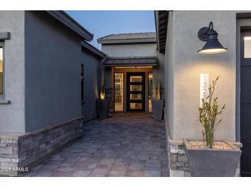 Inviting front entrance with a modern door, stylish planters, and exterior lighting that highlights the home's address at 13238 E Ranch Gate Rd, Scottsdale, AZ 85255