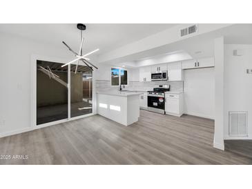 Modern kitchen with white cabinets, stainless steel appliances, and an island at 1387 N 44Th St, Phoenix, AZ 85008