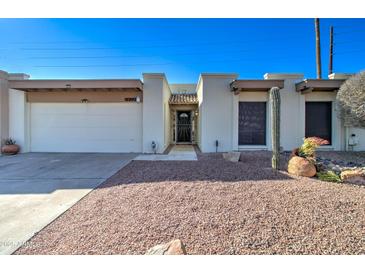 Tan stucco house with a brown door and a gravel yard at 14228 N Yerba Buena Way, Fountain Hills, AZ 85268