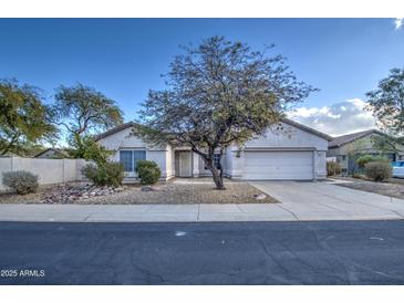 Single-story home with a two-car garage and nicely landscaped front yard at 14905 W Dovestar Dr, Surprise, AZ 85374