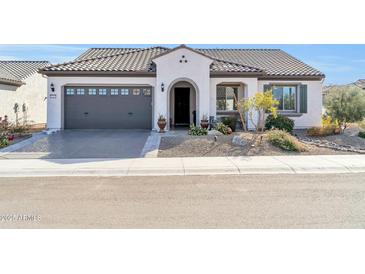 Single-story home with a gray garage door and well-manicured landscaping at 18961 N 264Th Ave, Buckeye, AZ 85396