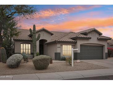 Charming single-story home featuring desert landscaping and a tile roof set against a vibrant sunset sky at 20490 N 78Th Way, Scottsdale, AZ 85255