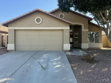 One-story house with beige exterior, attached garage, and small front yard at 20901 N 84Th Dr, Peoria, AZ 85382