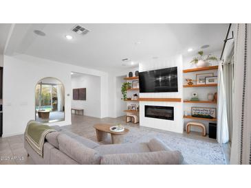 Bright living room features a fireplace and built-in shelving at 23776 N 167Th Ln, Surprise, AZ 85387