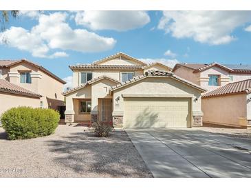 Two-story house with a beige exterior, two-car garage, and landscaped front yard at 28125 N Silver Ln, San Tan Valley, AZ 85143