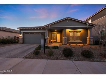 Charming single-story home with neutral gray exterior, brick driveway, manicured landscape, and covered porch at 4752 S Orbit Ave, Mesa, AZ 85212