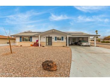 Ranch style home with carport, solar panels, and landscaped yard at 6252 E Billings St, Mesa, AZ 85205