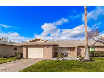 Single story home with attached garage and well-maintained lawn at 9920 W Shasta Dr, Sun City, AZ 85351