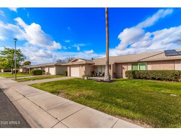 Front view of house showcasing landscaping and street view at 9920 W Shasta Dr, Sun City, AZ 85351