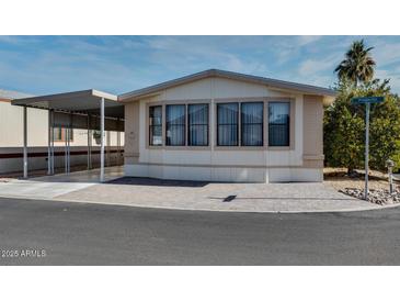 Single-wide manufactured home with carport and paved driveway at 17200 W Bell Rd # 1581, Surprise, AZ 85374