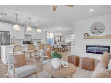 Open concept kitchen and living area, featuring modern appliances and a fireplace at 17574 W Cardinal Dr, Goodyear, AZ 85338