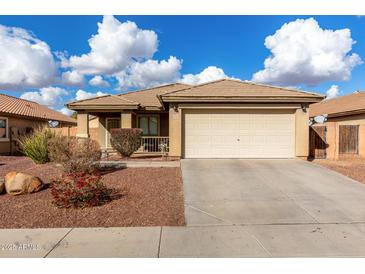 One-story house with beige exterior, attached garage, and landscaped front yard at 25700 W St James Ave, Buckeye, AZ 85326