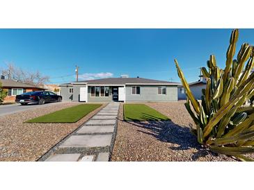 Cute bungalow with artificial turf, stone pathway, and mature cactus at 3714 E Amelia Ave, Phoenix, AZ 85018