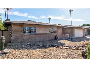 Brick ranch house with a two-car garage and landscaped yard at 4511 W Sandra Ter, Glendale, AZ 85306
