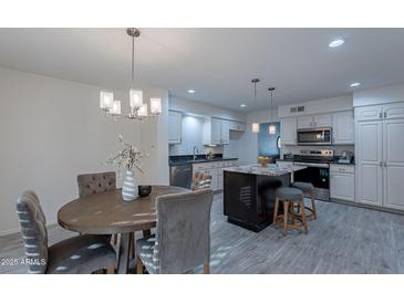 Updated kitchen features an island, stainless steel appliances, and dining area at 4914 E Lake Point Cir, Phoenix, AZ 85044