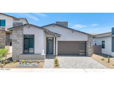 Stunning modern home with neutral stucco, stone accents, stylish garage door and desert landscaping at 6727 N 9Th Dr, Phoenix, AZ 85013