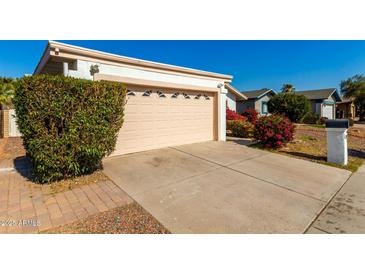 House exterior showcasing a garage and well-manicured landscaping at 10436 W Devonshire Ave, Phoenix, AZ 85037