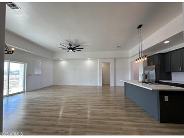 Bright and airy living room with hardwood floors and ceiling fan at 11615 S 211Th Ln, Buckeye, AZ 85326