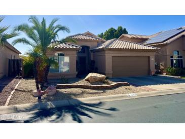 Tan house with tile roof, attached garage, and desert landscaping at 1233 E Redfield Rd, Phoenix, AZ 85022