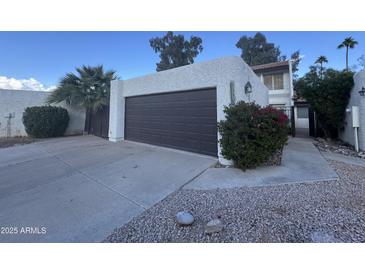 Spacious two-car garage featuring a private driveway and beautiful desert landscaping at 1501 S River Dr, Tempe, AZ 85281