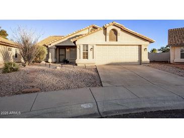 Tan house with a two-car garage and desert landscaping at 169 S Comanche Dr, Chandler, AZ 85224