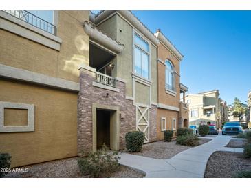 Multi-story tan and brown building with a private patio and stone archway entrance, surrounded by landscaped grounds at 18250 N Cave Creek Rd # 180, Phoenix, AZ 85032