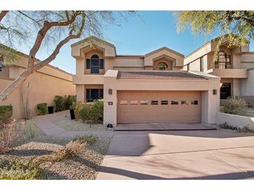 Two-story townhome with attached garage and landscaped walkway at 25150 N Windy Walk Dr # 11, Scottsdale, AZ 85255