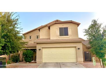 Two-story house with tan exterior, attached garage, and landscaping at 3621 W Glass Ln, Phoenix, AZ 85041