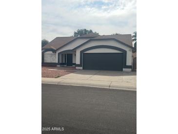 Charming single-story home with a well-manicured front yard and a two-car garage in a quiet residential neighborhood at 7685 W San Miguel Ave, Glendale, AZ 85303