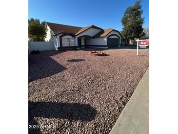 Single story home with rock landscaping and a fire pit at 7685 W San Miguel Ave, Glendale, AZ 85303