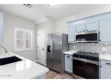 Modern kitchen with stainless steel appliances and light blue cabinets at 13185 W Calavar Rd, Surprise, AZ 85379